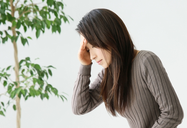 頭を抑える女性